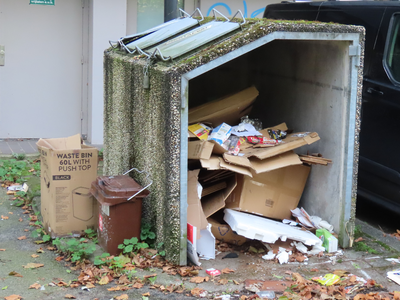 912127 Afbeelding van een kapotte betonnen papiercontainer op het parkeerterrein naast het voormalige kantoorgebouw De ...